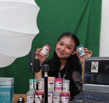 A smiling content creator holds Swisse vitamins during a product photoshoot with a green screen and studio lighting.