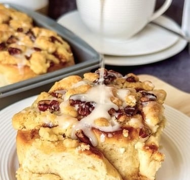 single apple-cinnamon roll with streusel-nut topping just getting the icing drizzle - (c) BREADISTA and Chew on This