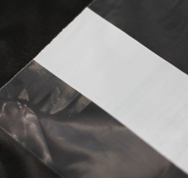 Detalhe da faixa branca do saco transparente.