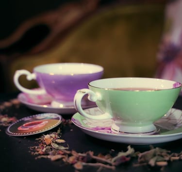Two tea cups, one green, one purple, containing tea, the image links to Wicked Wolf daytime tea menu