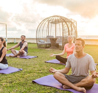 Group of people doing yoga in a field.