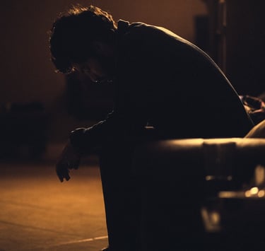 Man sitting alone on a bench at night, signifying depression and pain.