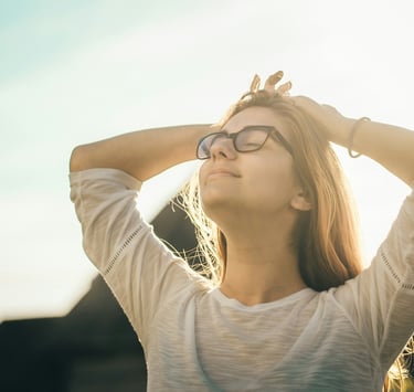 Young woman with hands behind her head, feeling relief from her pain.