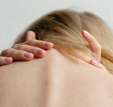 Young woman holding the back of her neck, demonstrating musculoskeletal pain.