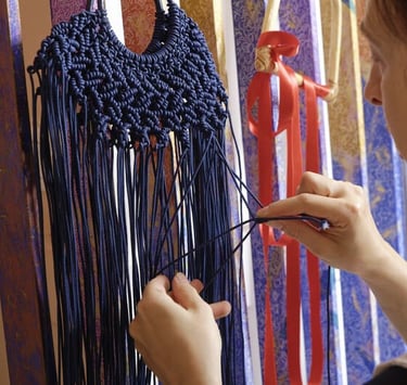 artesana tejiendo macramé en un color azul marino