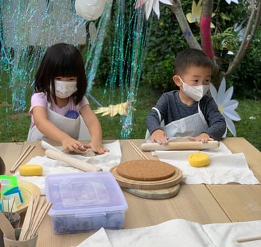 a group of children wearing masks while making pottery