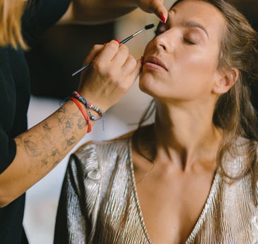 une femme se fait maquiller par une maquilleuse professionnelle