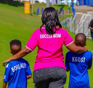 a woman in a pink shirt is holding a soccer ball