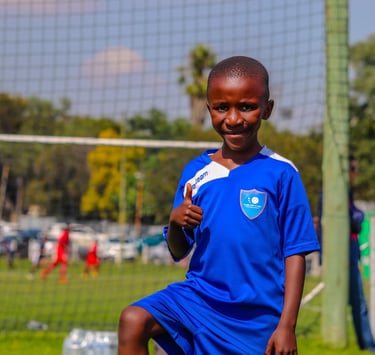a young boy is playing soccer on a soccer field