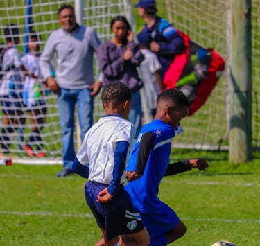 two boys playing soccer on a soccer field