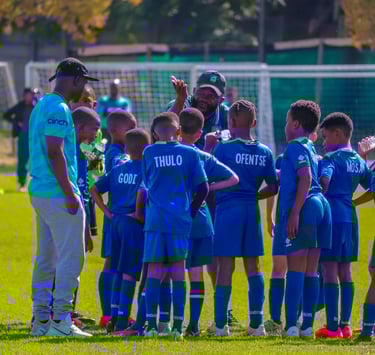 a group of young boy soccer players standing in a circle