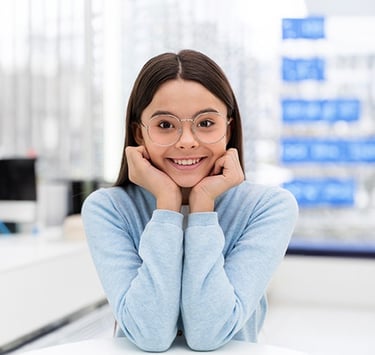 a woman in glasses and a blue sweater