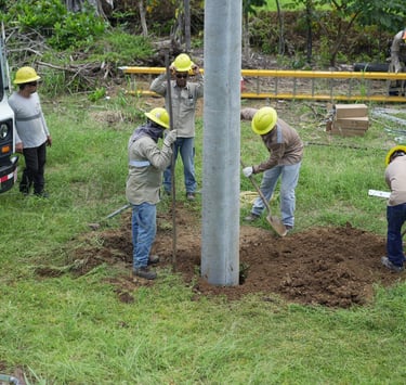 grupo de hombres haciendo un hoyo para instalacion de poste electrico
