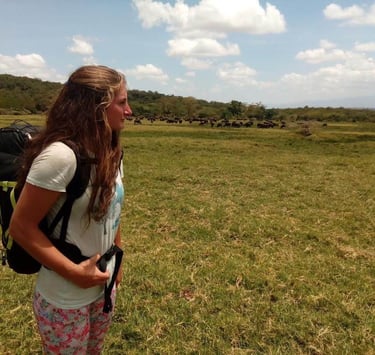 Tourist standing on the savannah landscape in Tarangire National Park observing wildlife during a Tanzania safari tour.