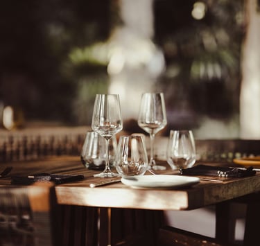 a table with wine glasses in a restaurant.Sustainability in Hospitality with Timea Pokol Consultant