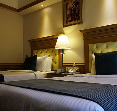 a hotel room with two beds and a lamp. Revenue Management for Hotels with Tímea Pokol Consultant