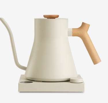 Cream-colored electric gooseneck kettle with a wooden handle on a matching minimalist heating base.