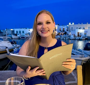 a smiling woman sitting at a table with a menu