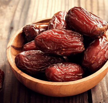 Bowl of dates in a wooden container, symbolizing patience and legacy.