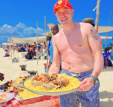 Fresh seafood lunch served on a sandbank during Safari Blue Zanzibar tour, including lobster, fish, and tropical fruits