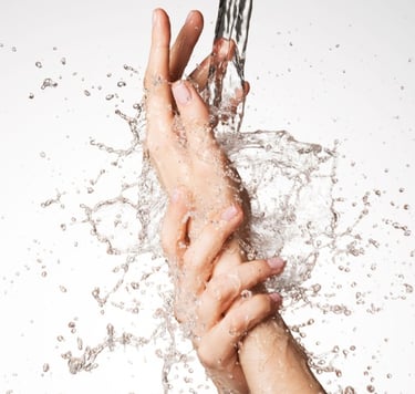 a person's hand holding a knife and a knife in the water