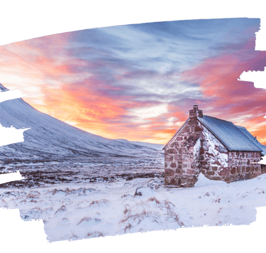 Snow-covered Cairngorm mountains in winter as the sun sets over the Highlands
