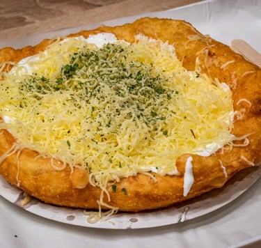 a lángos with cheese and cheesecakes on a plate