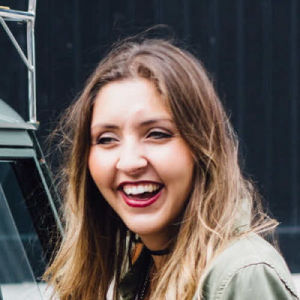 a woman with long hair and a green jacket
