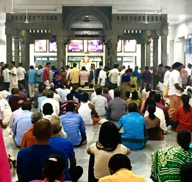 a group of people sitting on the ground in a temple