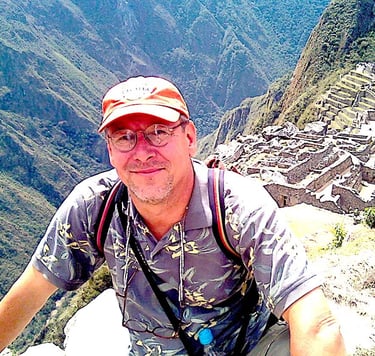 John in a hat and a backpack at Machu Picchu, Peru
