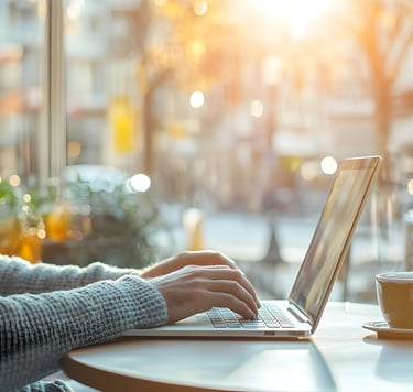 a man sitting at a table with a laptop computer