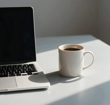 A minimalist and elegant South American / Brazilian office setting with a sleek laptop and a ceramic mug of coffee. Soft morning light creates long shadows on a light grey-blue surface. The atmosphere is calm and focused, reflecting contemporary elegance with soft off-white accents.