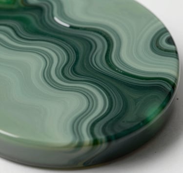 Macro photography of a fluid resin art piece with swirling textures in deep forest green and muted sage green. The surface is glass-like and glossy, reflecting soft studio lighting. Elegant and modern composition.