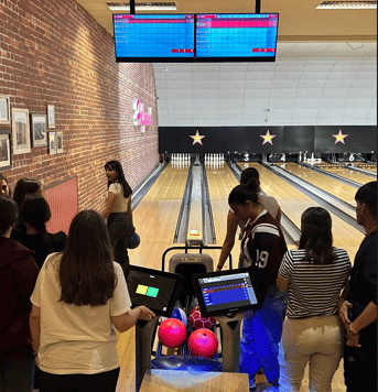 Un grupo de estudiantes jugando a los bolos en una bolera cubierta 