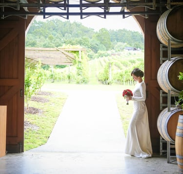 Mariage dans les vignes, mariée avec bouquet de roses rouges, décoration tonneaux