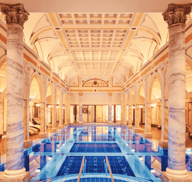 a large luxury indoor swimming pool with a blue tiles