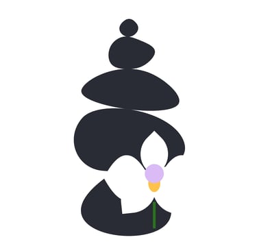 A black rock cairn with a white orchid which has a lavender & tangerine center