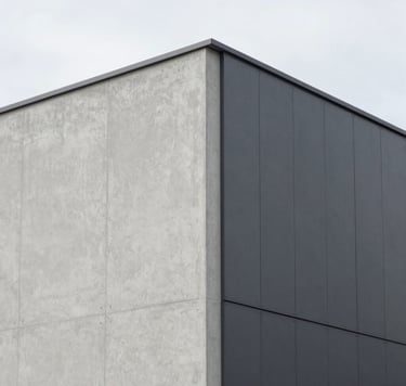 An architectural detail shot of a modern, minimalist building facade in Northern Europe. The image focuses on the sharp, clean intersection of light gray concrete and dark gray metal panels. Sophisticated simplicity and precision are highlighted by the soft, overcast daylight. Artistic and professional composition.