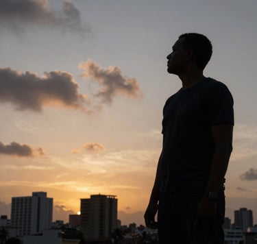 A moody, low-angle shot of a film director's silhouette standing against a sunset over the city of Luanda, Angolana architecture in the background, slate grey clouds and antique gold horizon lines.