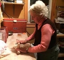 a woman in a red sweater and jeans, cooking