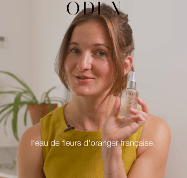 a woman in a yellow dress holding a bottle of cosmetic