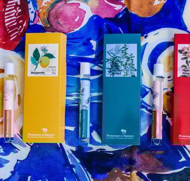 a variety of different colored rollerball perfumes on a colorful tablecloth