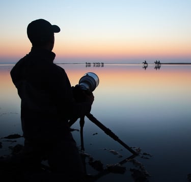 a photographer with a hat and holding a camera