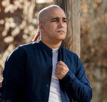 Hombre con camisa azul y camiseta blanca en un paisaje, retrato, redes, sesión, imagen corporativa.