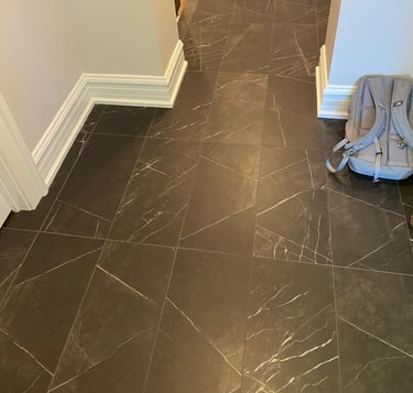 Basement hallway with natural stone flooring leading to finished living and storage areas