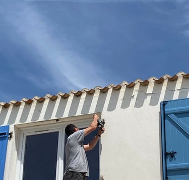 artisan menuisier qui pose un volet sur une maison en Vendée