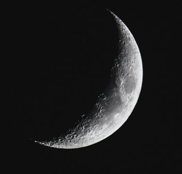 a crescent moon in the dark sky