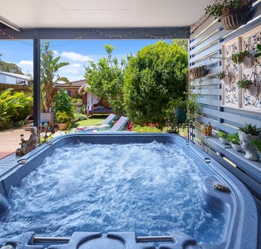 Outdoor spa at Marché Nude Stay surrounded by tropical greenery.