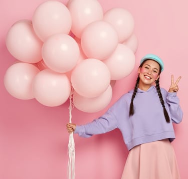 a woman in a blue sweater holding a bunch of balloons