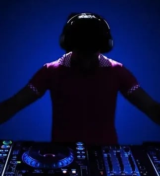 Silhouette of a disc jockey wearing a headset, DJing at turntables. DJ